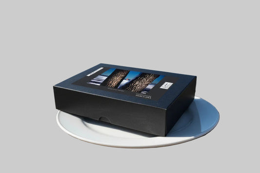 Your Suggested Brand Black rectangular jigsaw puzzle box on dinner plate in an outdoor setting. serving size 1 puzzle and it's calorie free. 